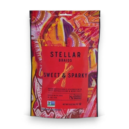 A vibrant bag of STELLAR SNACKS - SWEET & SPARKY PRETZEL BRAIDS, showcasing bold red and orange abstract artwork, flavorful buffalo-inspired seasoning, and clear product information on the front—the ideal pick for those who love spicy snacks.
