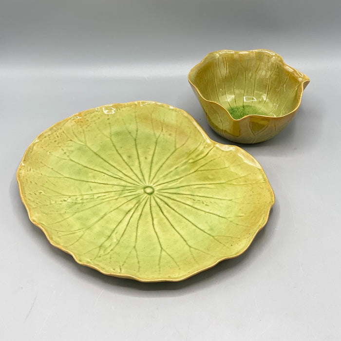 The CREATIVE COOP STONEWARE WATER LILY PLATE WITH BOWL IN REACTIVE CRACKLE GLAZE features veined, green leaf shapes and wavy edges, resembling natural leaves from the side view.