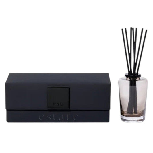 A black rectangular ZODAX gift box with a small label sits beside the THISTLE ESTATE DIFFUSER - 200 ML, featuring black reeds and scented liquid for a refreshing California coast fragrance.