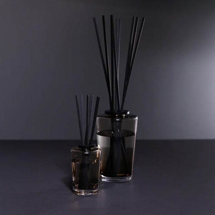 A black rectangular ZODAX gift box with a small label sits beside the THISTLE ESTATE DIFFUSER - 200 ML, featuring black reeds and scented liquid for a refreshing California coast fragrance.
