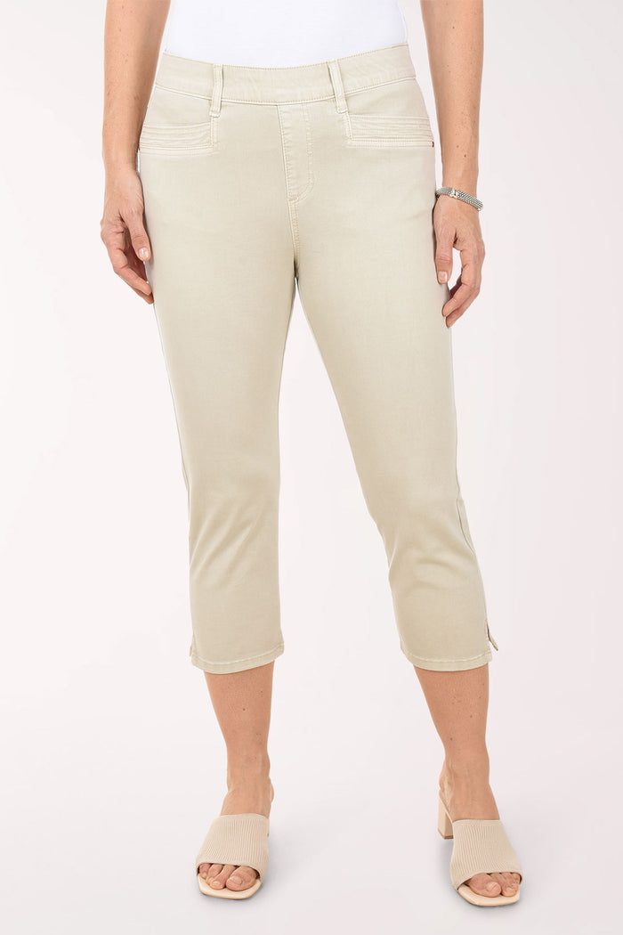 Person wearing beige capri pants on a white background