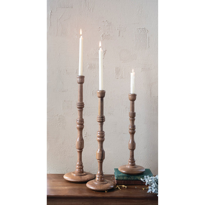 The CREATIVE COOP TURNED MANGO WOOD TAPER HOLDER, SMALL, features a traditional baluster-style stem and round base in mango wood, showcased on a white background.