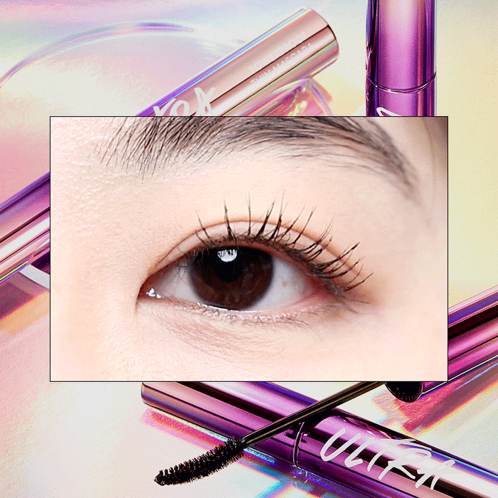 Application of MISSHA Ultra Powerproof Thin Mascara with a brush, displayed on a reflective surface with a colorful, holographic background.