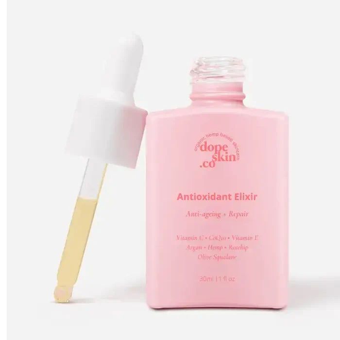 Pink bottle of 'dope skin co' Antioxidant Elixir with a brush on a white background