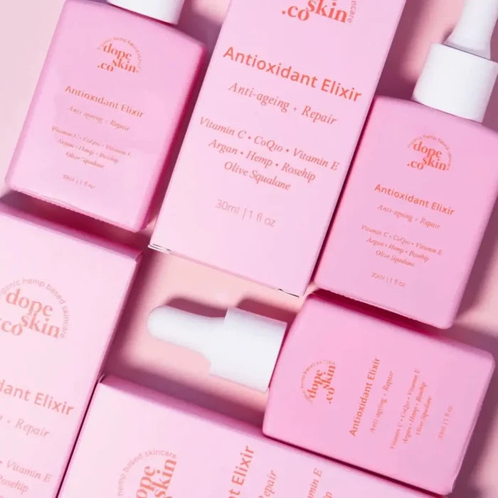 Pink bottles of 'dope skin co' Antioxidant Elixir on a pink background