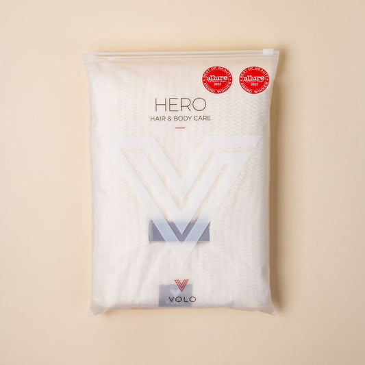 A packaged VOLO BEAUTY - HAIR HERO TOWEL features two red "Allure Best of Beauty" award stickers, a large semi-transparent V-shaped logo, and promotes its Nanoweave fabric for frizz-free hair.