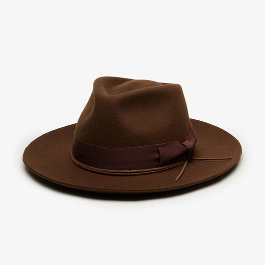 The WYETH - TEDDY HAT IN BROWN by WYETH is a vintage-inspired wide-brimmed fedora with a matching dark brown ribbon band, shown against a plain white background.